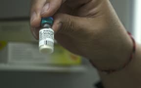 Dr Richard Hulme holding Measles Vaccine
