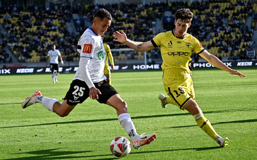 Neyder Moreno of Auckland and Isaac Hughes of the Phoenix compete for the ball.