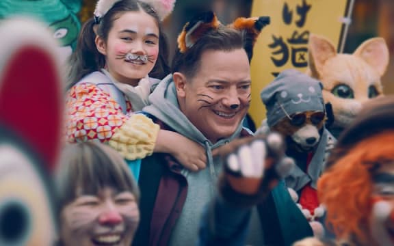 Shannon Gorman as Mia Kawasaki piggybacks on Brendan Fraser as Phillip Vanderploeg in the film Rental Family.