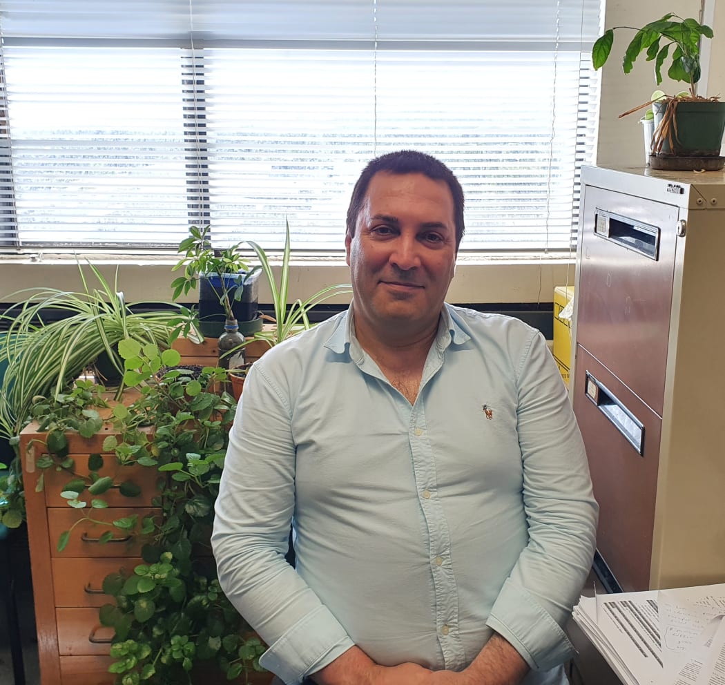 A photo of Hossein Alizadeh seated in front of his many plants in his office at Lincoln University