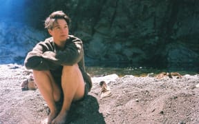 A photo of Sylvan Thomson by a river