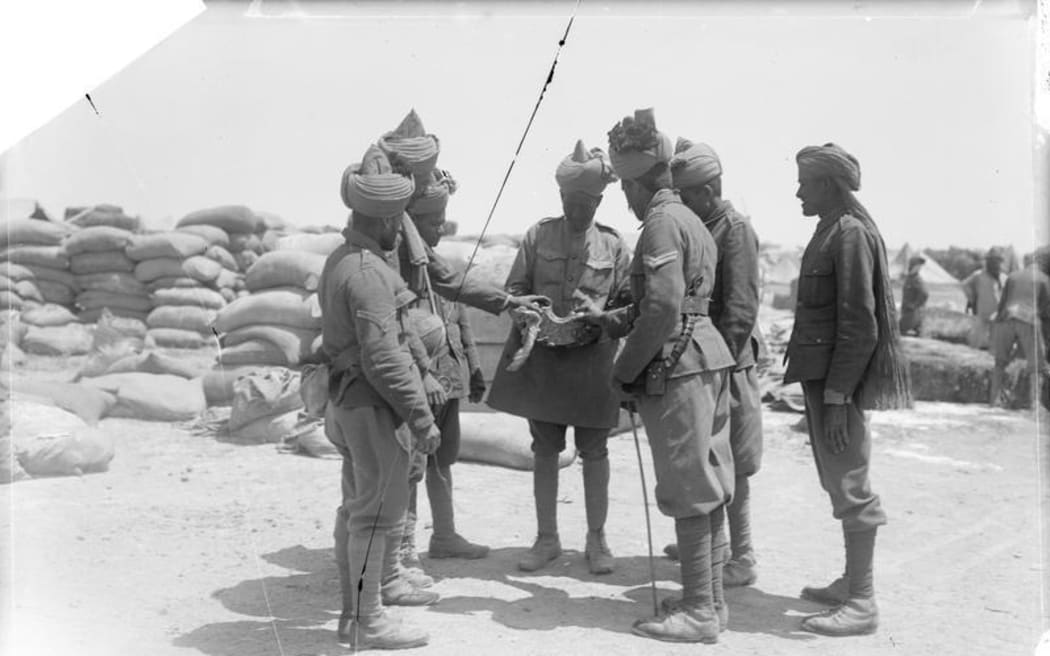 THE GALLIPOLI CAMPAIGN, APRIL 1915-JANUARY 1916: Troops of the 14th Sikhs of the 29th Indian Infantry Brigade examining a piece of shell from 'Asiatic Annie' that fell in their camp.