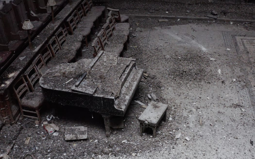 A photo taken inside the Christ Church Cathedral shows a piano covered in dust and debris, in Christchurch on 16 August 2022.