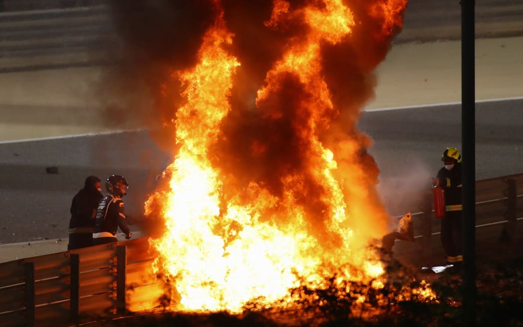 Fire marshals put out a fire on Haas F1's French driver Romain Grosjean's car during the Bahrain Formula One Grand Prix, 2020.