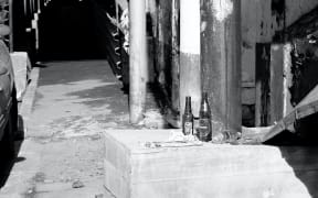 Empty alcohol bottles on steps by a footpath.