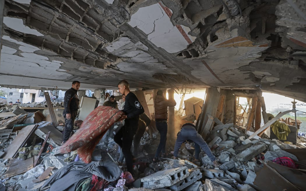 People search for their belongings amid the debris of destroyed houses in the aftermath of Israeli bombardment in Rafah in the southern Gaza Strip on February 22, 2024, amid continuing battles between Israel and the Palestinian militant group Hamas. (Photo by MOHAMMED ABED / AFP)