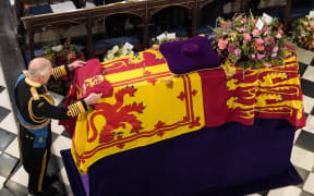 King Charles III places the the Queen's Company Camp Colour of the Grenadier Guards on the coffin during the Committal Service for Britain's Queen Elizabeth II in St George's Chapel inside Windsor Castle on September 19, 2022. (Photo by Jonathan Brady / POOL / AFP)