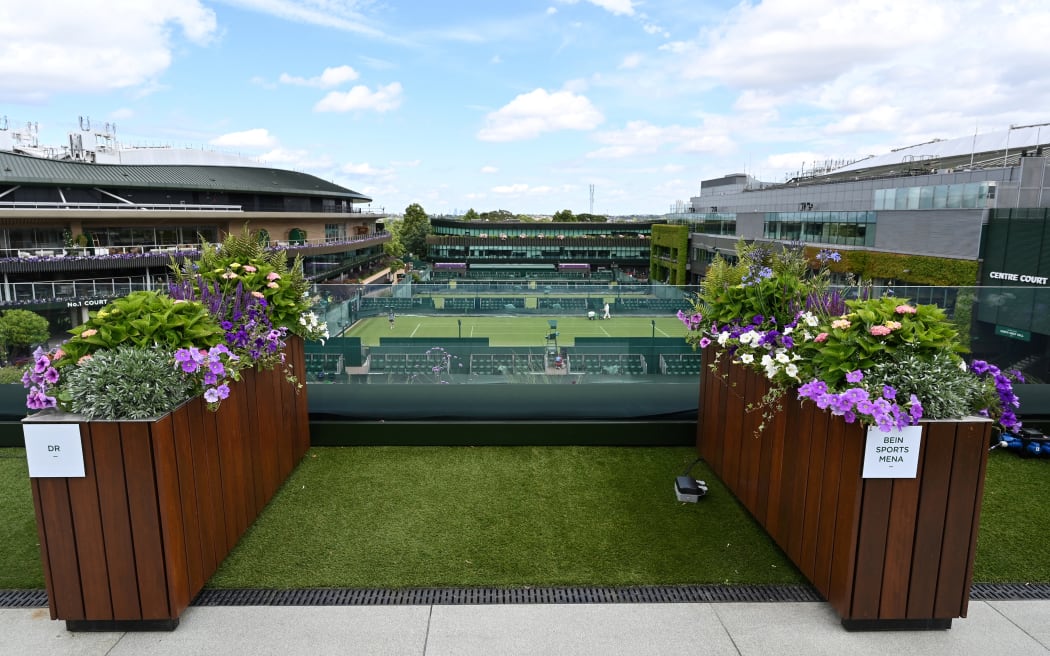 A photograph taken on June 24, 2025 shows planter separating TV crews on the roof of the broadcast centre in the grounds of the All England Lawn Tennis & Croquet Club in Wimbledon, south west London. Wimbledon head gardener Martyn Falconer is the only man at the All England Club who welcomes a spot of rain during Wimbledon tennis tournament to help keep his flowers in tip-top shape. He oversees the delivery of 27,000 plants specifically for the Championships in leafy southwest London to add to thousands already in place in the immaculate grounds. (Photo by GLYN KIRK / AFP)