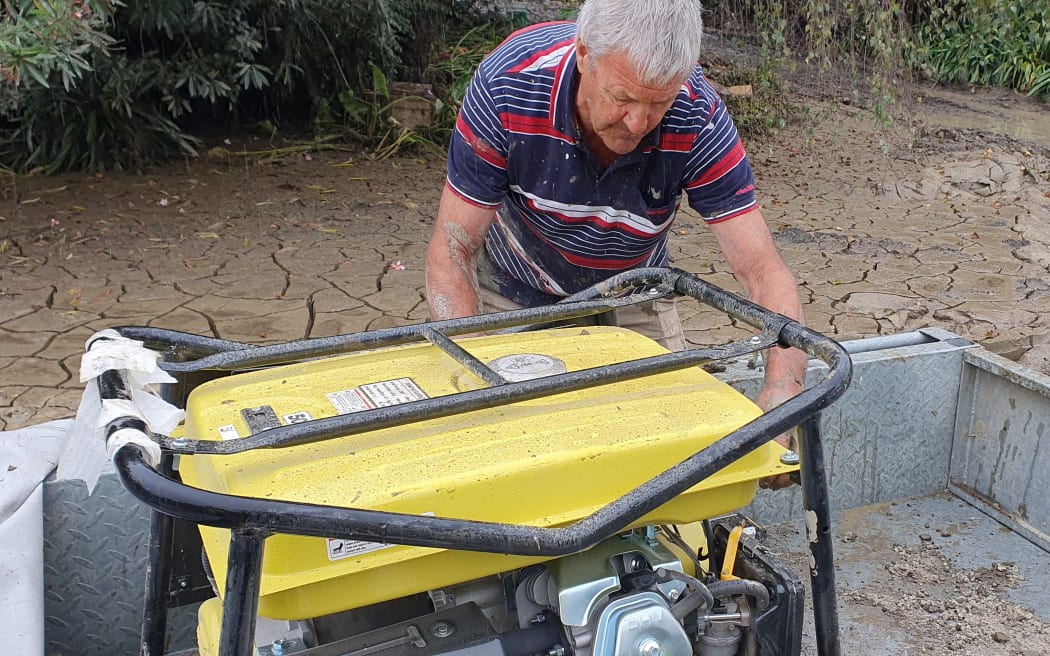 Keith Gore's brother, Errol, starts the generator to begin waterblasting silt.