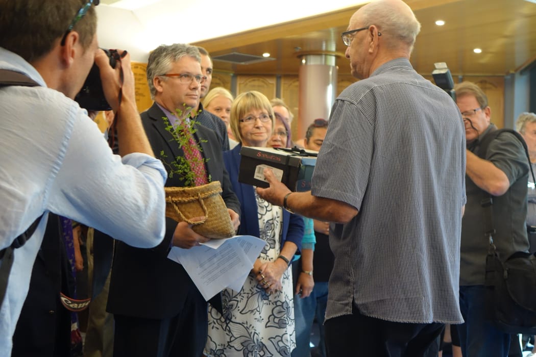 New Plymouth Mayor Andrew Judd (left) accepts a petition from Hugh Johnson which is likely to spark a referendum on the establishment of a designated seat for Maori on council.