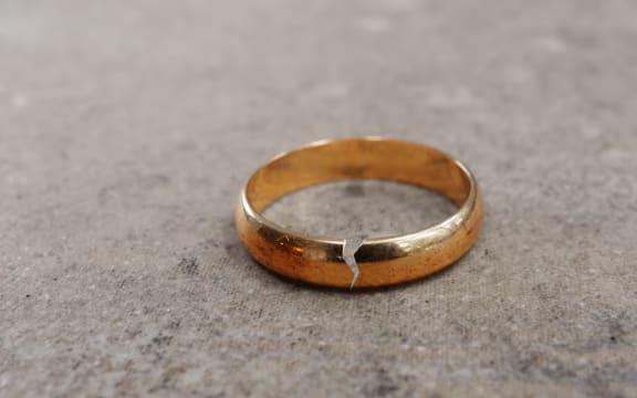 A gold wedding ring with a crack in it.