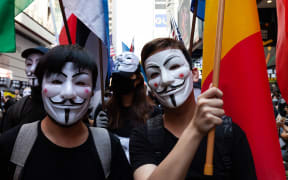 Hong Kong Protester wearing masks and marching with flags representing the countries that mentioned they support to Hong Kong protester, in Hong Kong, China, on October 1, 2019.
