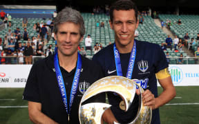 Auckland City coach Ramon Tribulietx and captain Angel Luis Viña Berlanga pose with the OFC trophy.