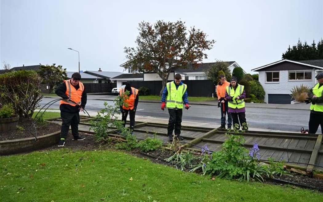 Student Volunteer Army helping out in community areas and taking down a fence.