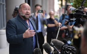 Alex Jones speaks to media after arriving at the courthouse for a hearing in front of a bankruptcy judge Friday, 14 June, 2024, in Houston.