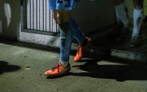 A football player heads from the locker room to the field during a night game.