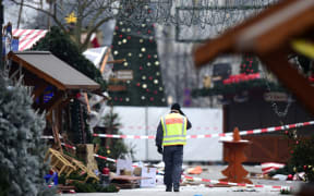 A policeman walks at the Christmas market near the Kaiser-Wilhelm-Gedaechtniskirche (Kaiser Wilhelm Memorial Church), the day after a terror attack, in central Berlin, on December 20.
