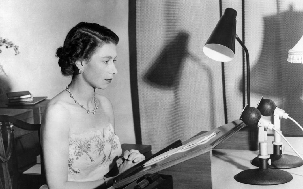 The Queen Elizabeth II, wearing a strapless evening gown, makes her Christmas broadcoast to the peoples of the British Commonwealth, 31 December 1953 from Government House, Auckland.
