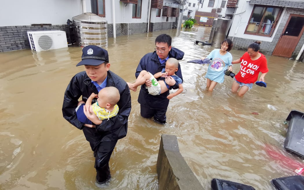 Policemen transfer the flood-stranded people in Putuo scenic area of Zhoushan City, east China's Zhejiang Province, Aug. 10, 2019.