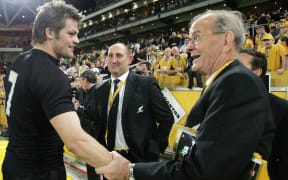 Former All Black captain John Graham congratulates All Blacks captain Richie McCaw after victory over the Wallabies in 2006. Antoher former All Black captain the late Sir Jock Hobbs looks on.