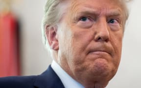 In this file photo taken on December 7, 2020 US President Donald Trump looks on during a ceremony presenting the Presidential Medal of Freedom to wrestler Dan Gable in the Oval Office of the White House in Washington, DC.