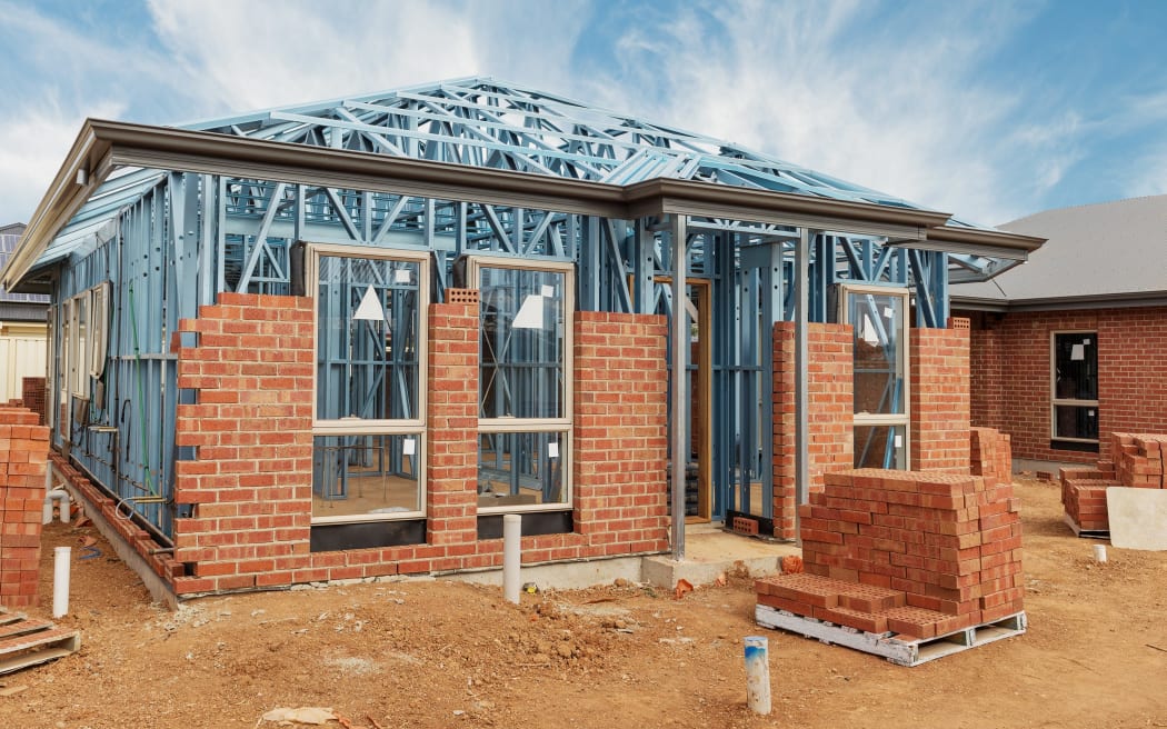 New residential construction home from brick with metal framing against a blue sky