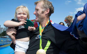 New Zealand's Mahe Drysdale celebrates gold with his daughter at the Rio Olympic.