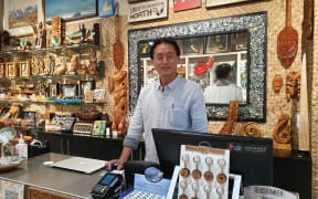 Benny Li, who has been operating souvenir shops on Auckland’s Queen St, is closing one of his two shops. He says businesses like his are struggling and hopes the trans-Tasman bubble can be up and running soon.