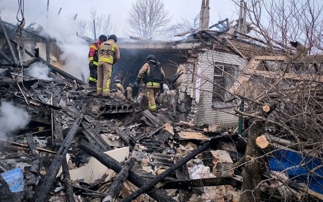 This handout photograph taken and released by the State Emergency Service of Ukraine on February 17, 2026, shows Ukrainian rescuers working in damaged private house at the site of a Russian attack in the Kyrykivka community of the Okhtyrka district Sumy region, amid the Russian invasion of Ukraine.
