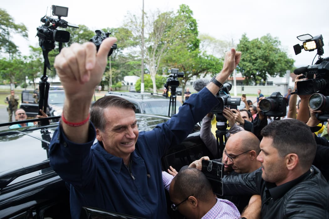 Brazil's right-wing presidential candidate for the Social Liberal Party (PSL) Jair Bolsonaro gives his thumbs up after casting his vote at Villa Militar, during general elections.