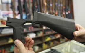 A bump stock device fits on a semi-automatic rifle to increase the firing speed.