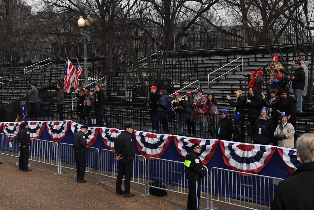 Supporters of US President Donald Trump and First Lady Melania Trump watch as they drive the inaugural parade route on Pennsylvania Avenue in Washington DC following swearing-in ceremonies on Capitol Hill.