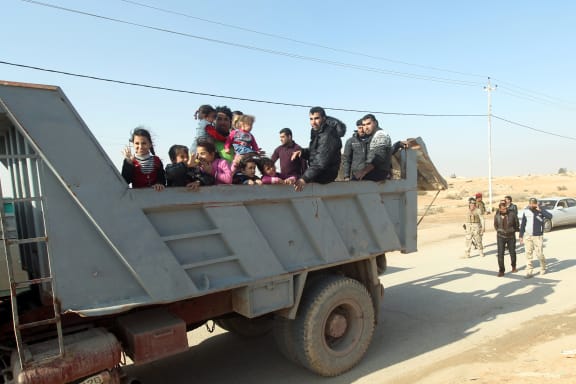 Sunni Muslim families leave their homes in Fallujah on Monday.