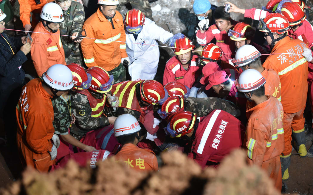 A survivor is found at the site of the landslide at an industrial park in Shenzhen, south China's Guangdong Province, Dec. 23, 2015. One man was pulled out alive early Wednesday morning more than 60 hours after a landslide in Shenzhen. (Xinhua/Liang Xu) (lfj)