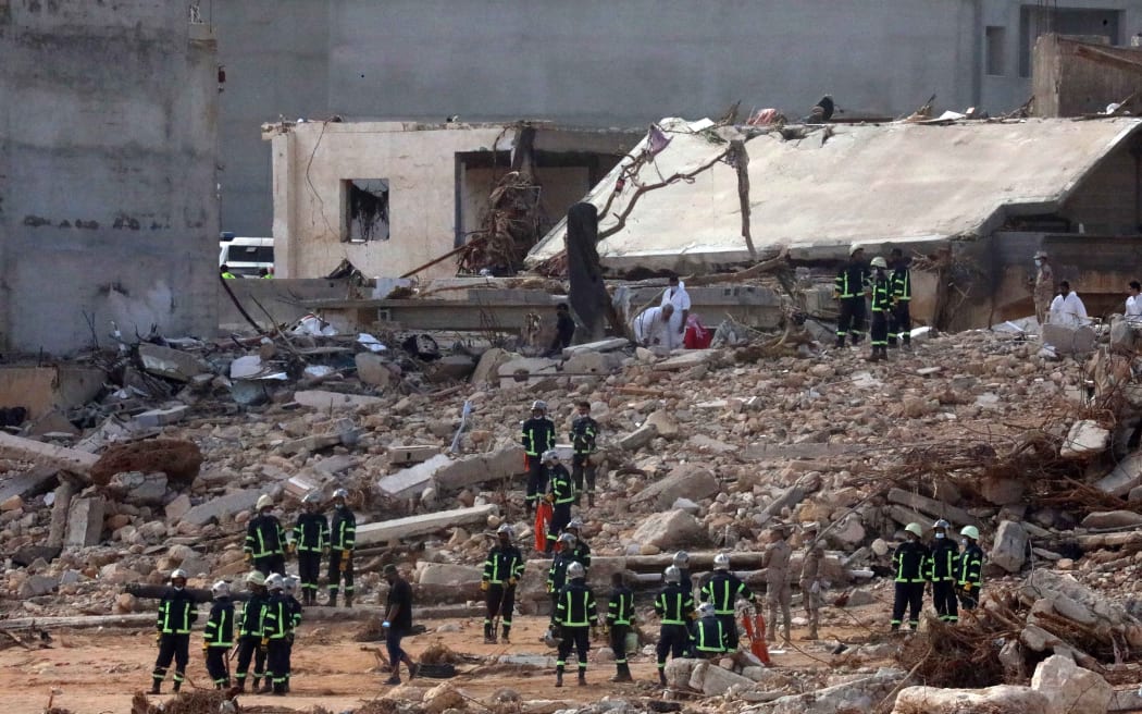 Rescuers gather amid the rubble of buildings damaged or levelled in flash floods after the Mediterranean storm "Daniel" hit Libya's eastern city of Derna, on 14 September, 2023. A global aid effort for Libya gathered pace on September 14 after a tsunami-sized flash flood killed at least 4,000 people, with thousands more missing, a death toll the UN blamed in part on the legacy of years of war and chaos.
