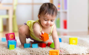 A photo of a toddler playing with blocks