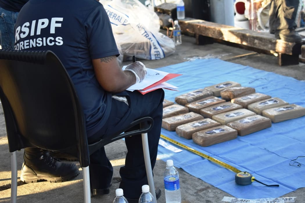 A Forensic officer in Solomon Islands recording the amount of cocaine being off-loaded from the yacht Vieux Malin in Honiara.