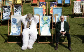 British author Raymond Briggs (R) and a snowman sit in a deckchair that Raymond designed based on his childrens story "The Snowman", at a photocall in London's Hyde Park on May 29, 2008. Deckchairs designed by various celebrities including Tracey Emin, Joanna Lumley and Raymond Briggs, will be sold at auction as part of a charity initiative entitled Deckchair Dreams 2008. AFP PHOTO/Shaun Curry (Photo by SHAUN CURRY / AFP)