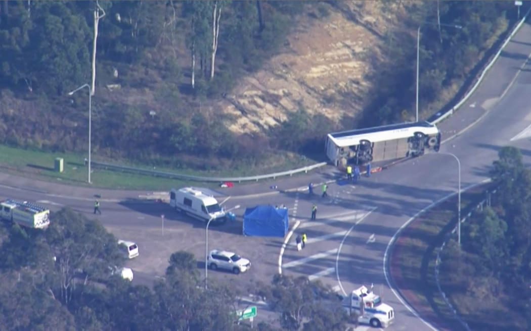 This frame grab taken from video footage provided by Australian Broadcast Corporation (ABC) on June 12, 2023 via AFPTV shows the site of a bus crash, where 10 people from a wedding party were killed, in Cessnock, in Australia's Hunter wine region north of Sydney. A wedding party bus crash killed 10 people in Australia's Hunter wine region north of Sydney, police said on June 12, announcing the arrest of the 58-year-old driver. (Photo by various sources / AFP) / Australia OUT / RESTRICTED TO EDITORIAL USE - MANDATORY CREDIT "AFP PHOTO / ABC" - NO MARKETING - NO ADVERTISING CAMPAIGNS - DISTRIBUTED AS A SERVICE TO CLIENTS