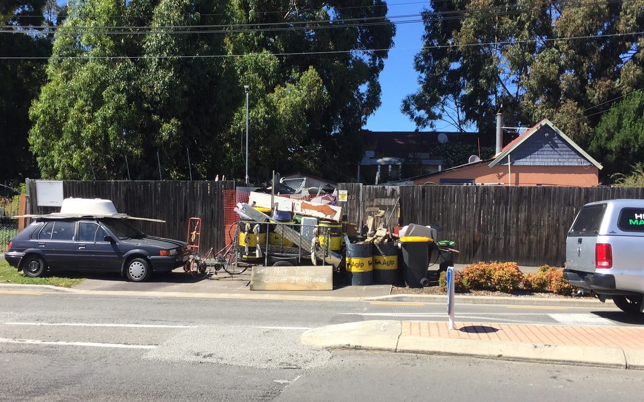 Miscellaneous items line the footpath of Grove Street address