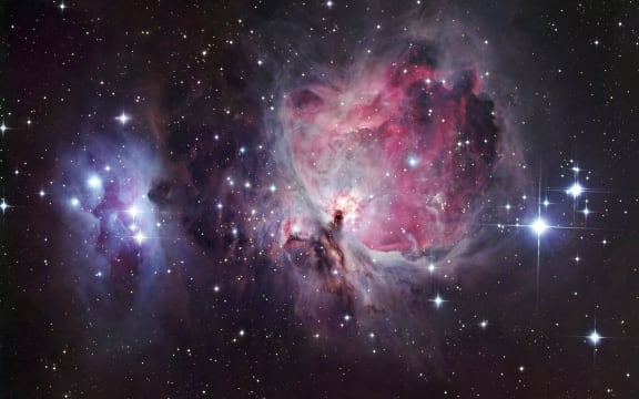 Orion nebula, optical image. North is at left. The Orion nebula can be seen with the naked eye as a fuzzy patch in the constellation Orion. It comprises several nebulae, but the brightest is M42 (pink, centre right). M43 is the small round nebula at lower centre, separated from M42 by a thin blue band of gas. M42 and M43 glow pink as the hydrogen they contain is ionised by radiation from hot young stars that recently formed inside them. In the case of M42, the stars that light it up are a group of four known as the Trapezium (just right of centre). The blue nebula NGC 1977 is at left. This nebula is not ionised, instead reflecting the light of nearby blue stars. The nebulae lie around 1500 light years from Earth. (Photo by ROBERT GENDLER/SCIENCE PHOTO LIB / RGN / Science Photo Library via AFP)