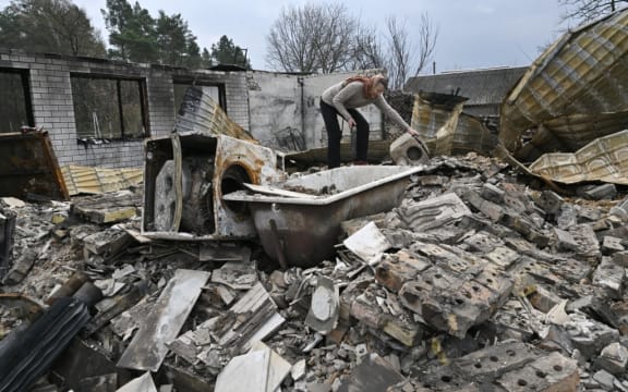 A woman examines the debris of her destroyed house in the village of Rusaniv, in the Kyiv region on 16 April.