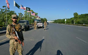 Pakistan Army soldiers stand guard in anticipation of former Prime Minister Imran Khan's supporters and activists amid the ongoing protests in Islamabad on October 6, 2024. - Pakistan's capital was locked down on October 5, swarmed by security forces with mobile internet cut as supporters of jailed ex-prime minister Imran Khan attempted to seize the streets in protest. (Photo by FAROOQ NAEEM / AFP)