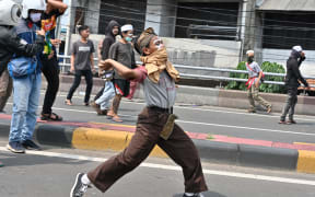 Protesters hurl rocks toward police during a clash in Jakarta.