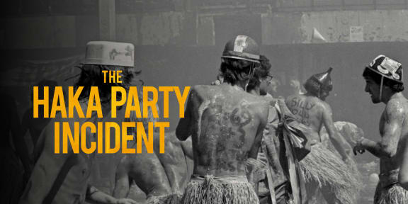 In a black-and-white photograph, a group of University of Auckland engineering students are gather while wearing odd hats and mock Māori piupiu. They have offensive, Māori-related terms written on their bodies. To the left of the image, in yellow font, reads: "The Haka Party Incident."