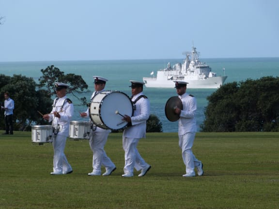 Members of the Navy band with frigate Te Kaha in the bay.