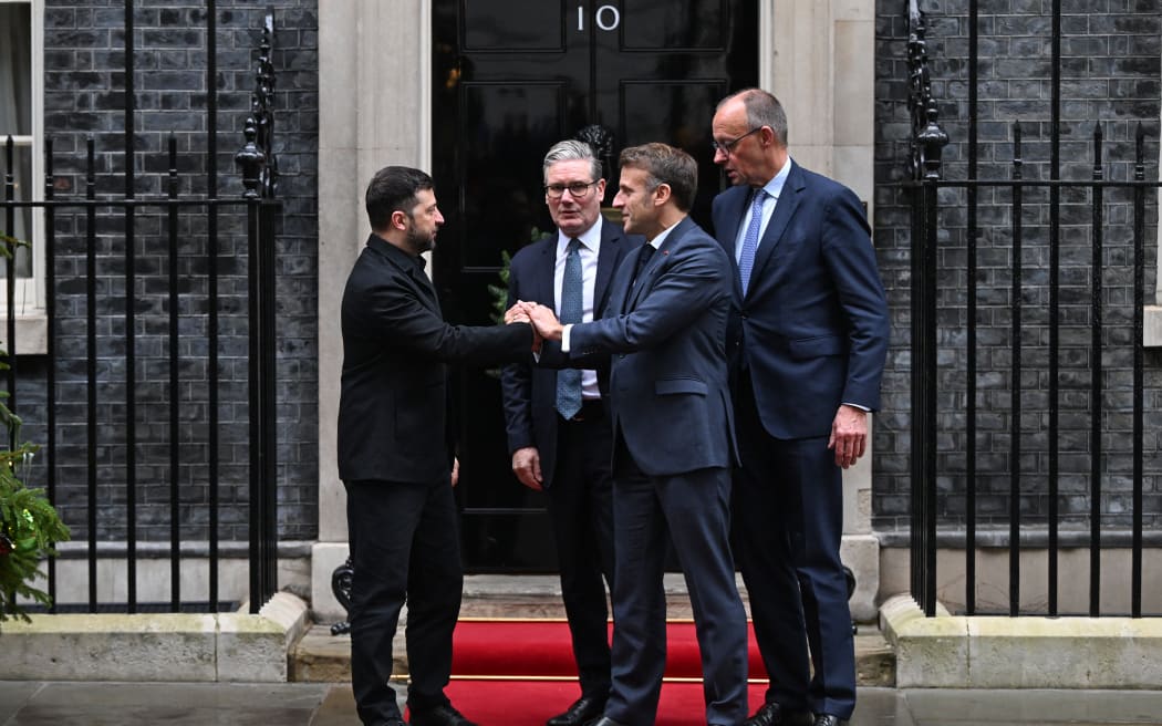 Ukraine's President Volodymyr Zelensky (L) shakes hands with French President Emmanuel Macron (front C) as Britain's Prime Minister Keir Starmer (2nd L) and Germany's Chancellor Friedrich Merz (R) look on outside Number 10 Downing Street following their talks in central London on December 8, 2025. (Photo by Chris J Ratcliffe / AFP)