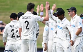 New Zealand's Will O’Rourke (L) and Rachin Ravindra (R) celebrate the dismissal of South Africa's Raynard van Tonder on day three of the second cricket test in Hamilton.