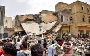 People gather at the scene near an explosion at a weapons warehouse in the city of Lawdar in Yemen's southern province of Abyan on July 5, 2022.