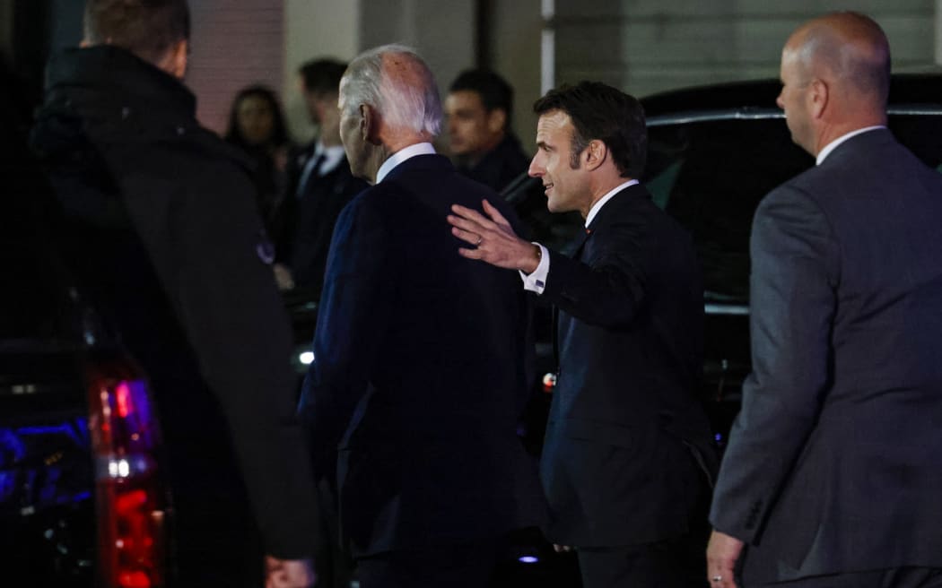 French President Emmanuel Macron (R) chats with US President Joe Biden as they leave Fiola Mare restaurant after a private dinner in Washington, DC, on 30 November, 2022.